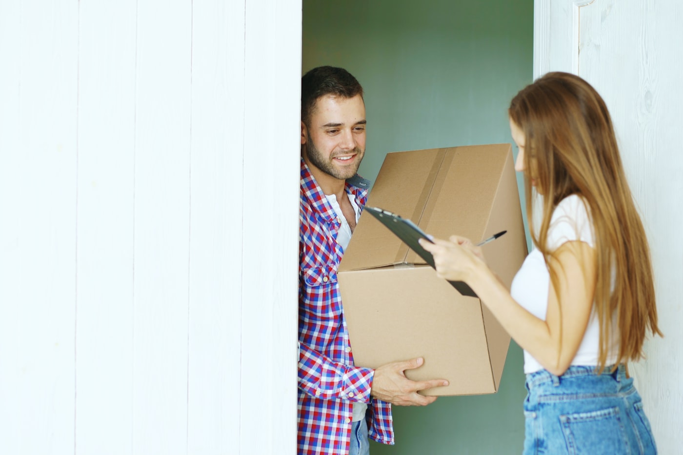A customer signing for a delivery at their front door