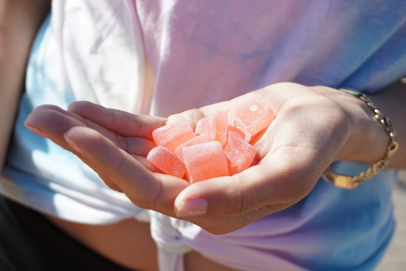 Hand holding pink cannabis edible gummies