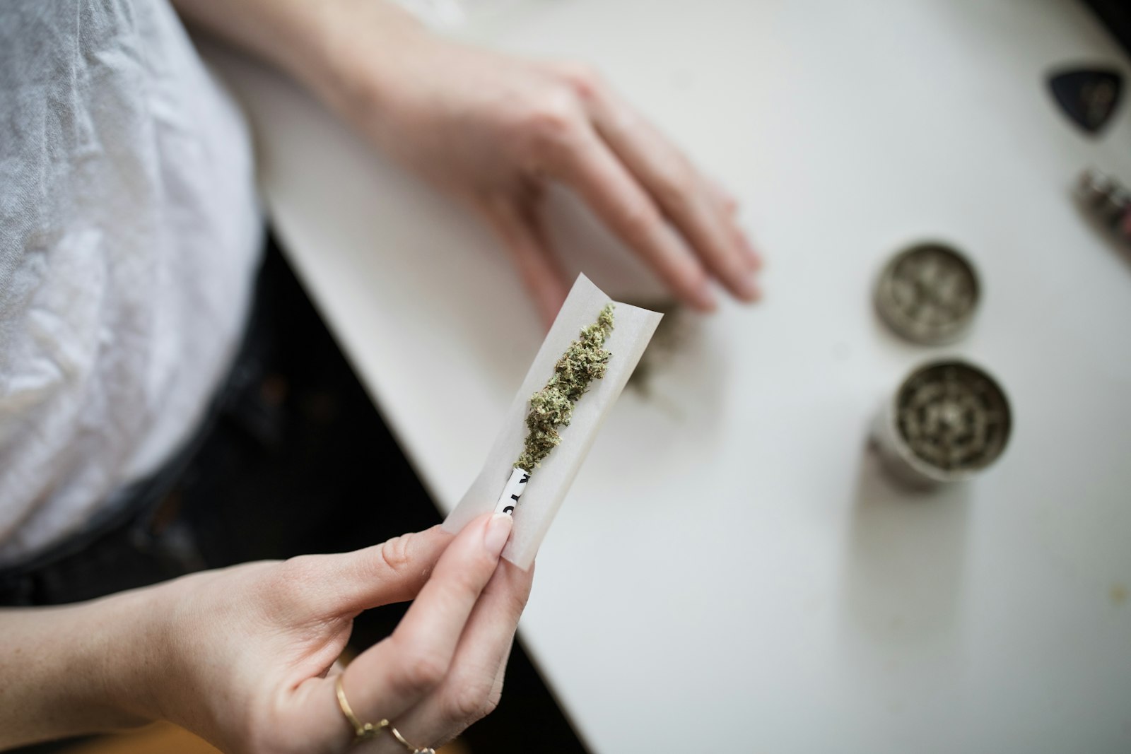 Hands preparing a cannabis joint.
